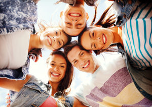 five teens with their heads in a circle smiling, teen treatment admissions process