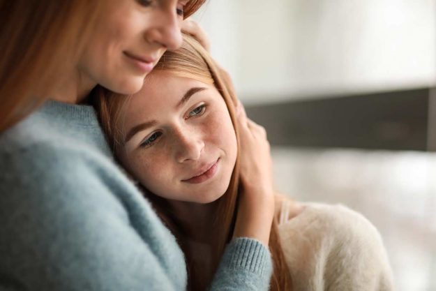 Mother embracing daughter explaining what are trauma triggers