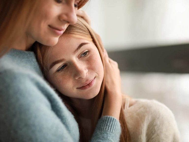 Mother embracing daughter explaining what are trauma triggers