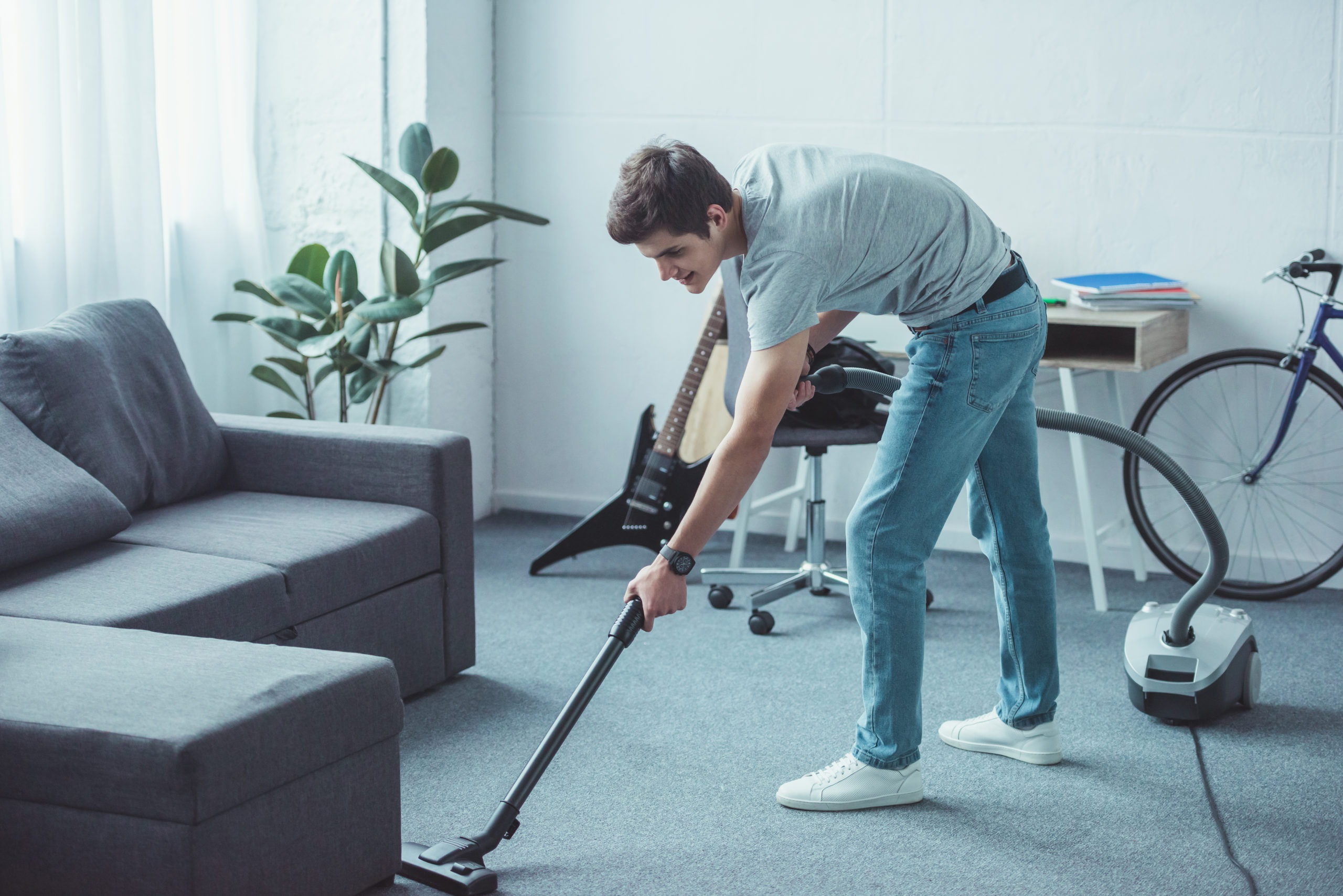 male teen with ocd symptoms cleaning floor with vacuum