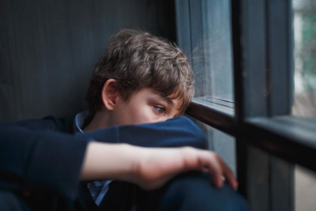 Adolescent looking out of the window wondering what it psychological dependence