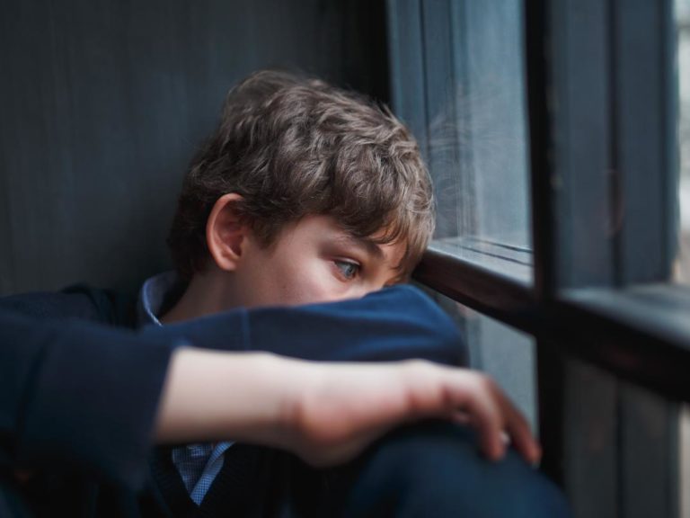Adolescent looking out of the window wondering what it psychological dependence