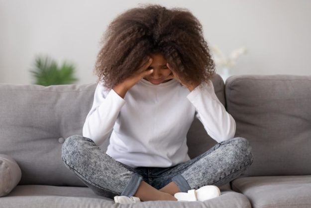 Child on couch thinking about trauma in teens