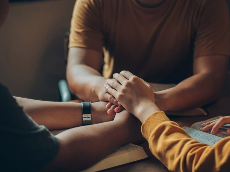 person in yellow shirt comforting another and helping them with coping with grief and loss