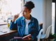 woman sitting by window considers what is double discrimination