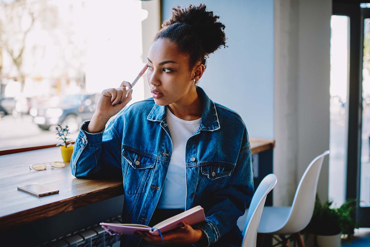 woman sitting by window considers what is double discrimination