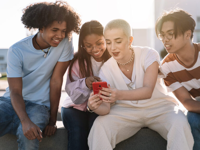 teens looking at a phone outside with social confidence