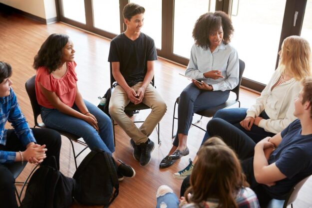 people talk in a circle about mental health first aid