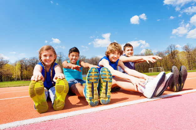 teens outside on a track stretching and discovering how physical activity improves mental health