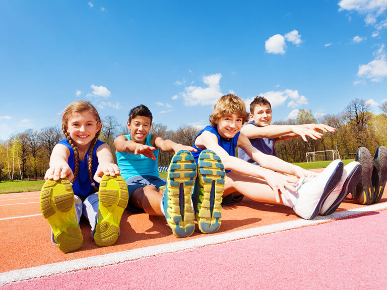 teens outside on a track stretching and discovering how physical activity improves mental health