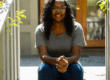 Dr. DaNiesha sits on steps and smiles