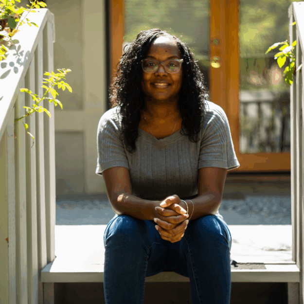 Dr. DaNiesha sits on steps and smiles