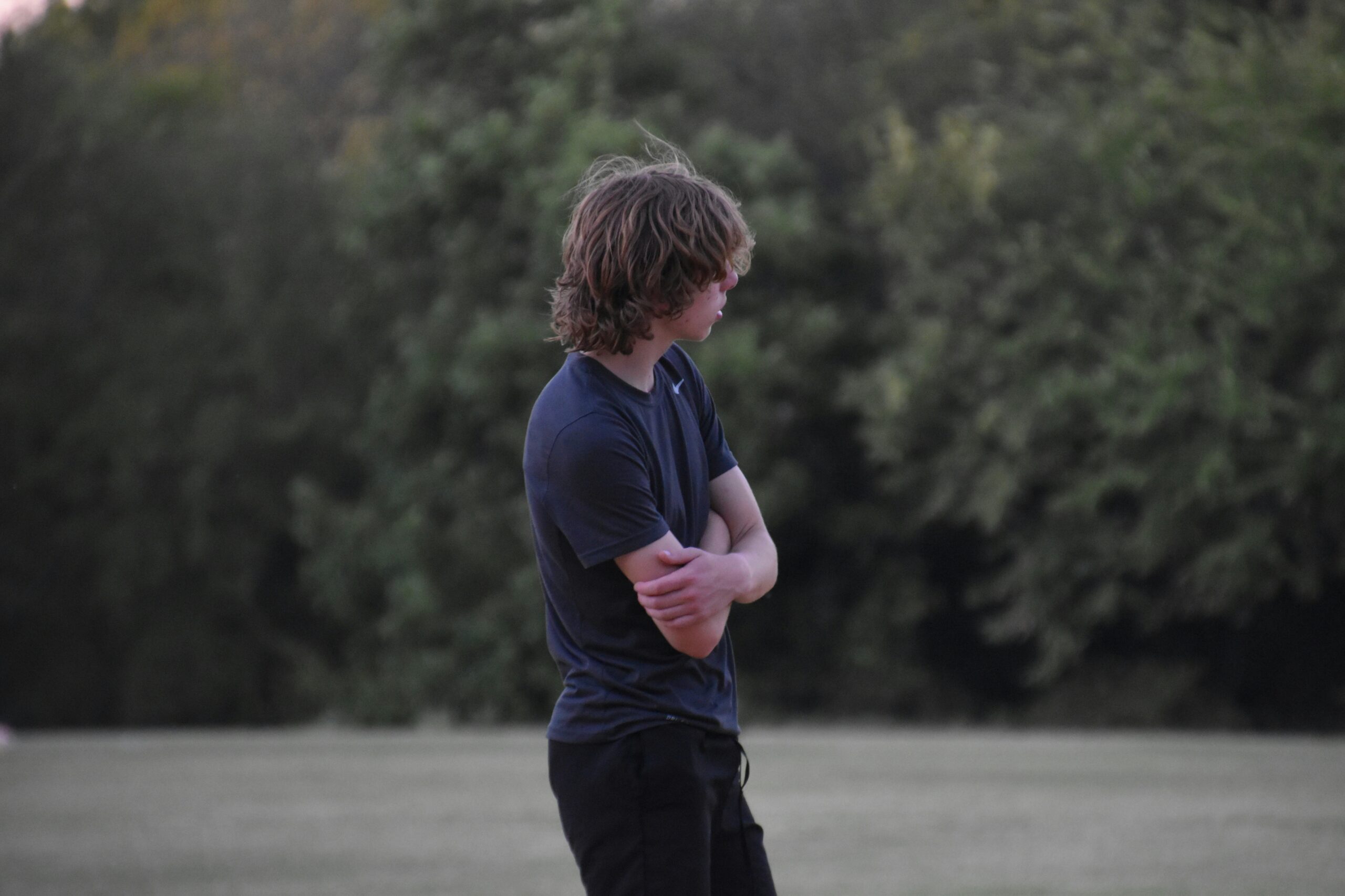teen boy standing alone looking depressed