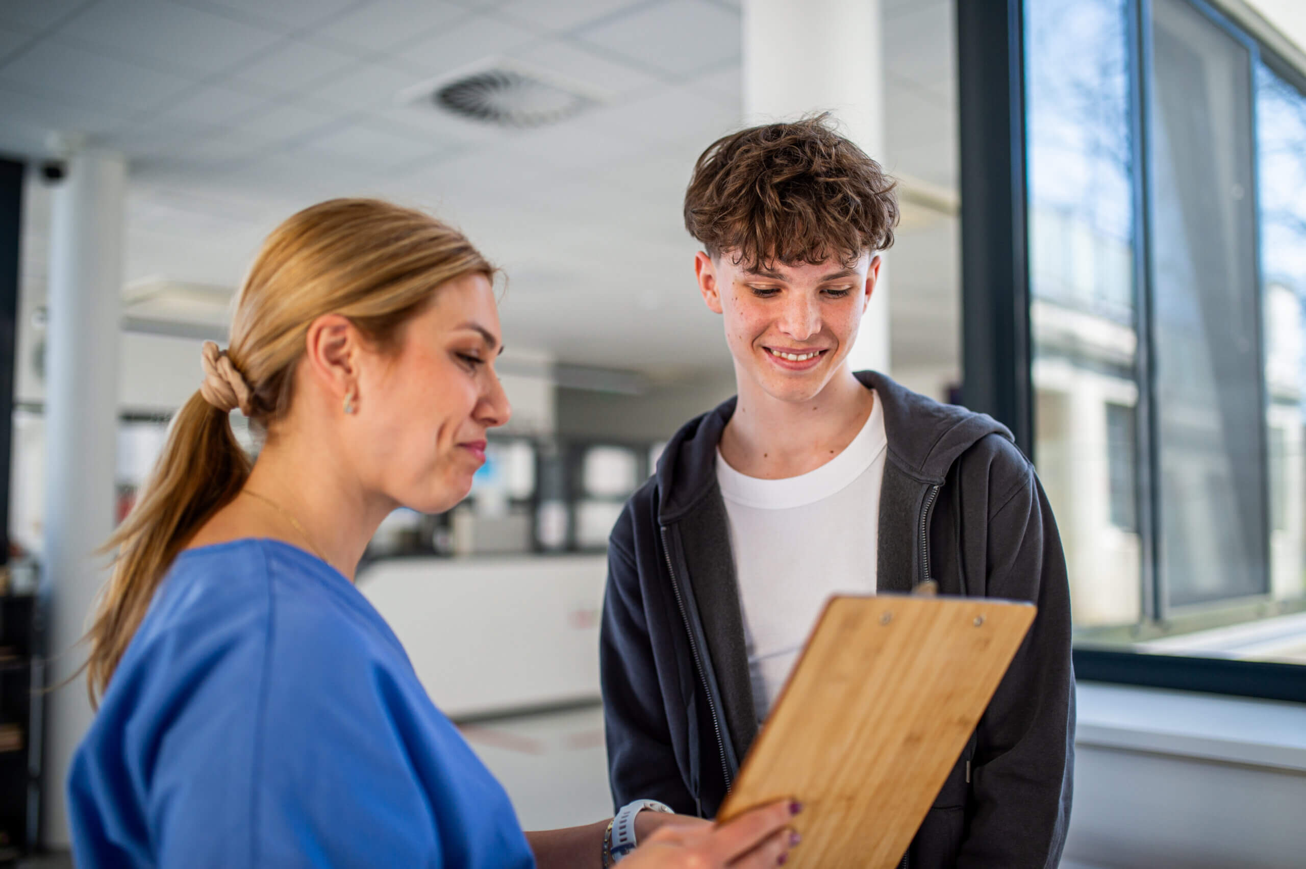 Doctor talking with teenage boy in medical clinic.
